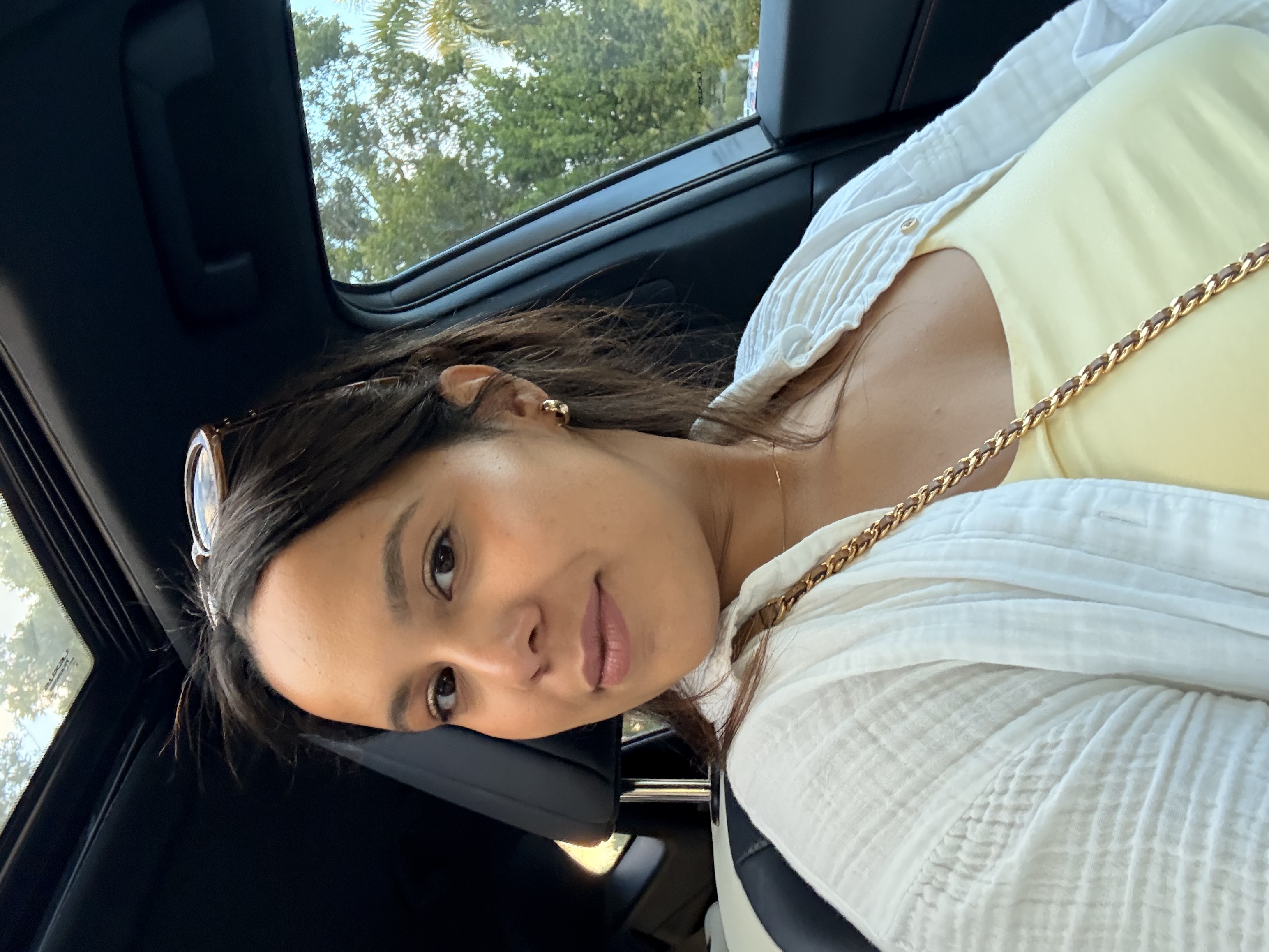 Karen in natural daylight wearing a cream shirt and gold jewelry